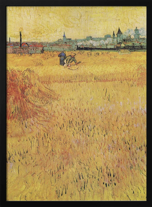 A Post-Impressionist painting by Vincent van Gogh depicting a vast, golden wheat field under a yellow sky. Two figures are harvesting wheat in the middle distance, with a town and industrial buildings on the horizon. The artwork is characterized by thick, textured brushstrokes and is displayed in a black frame. Print