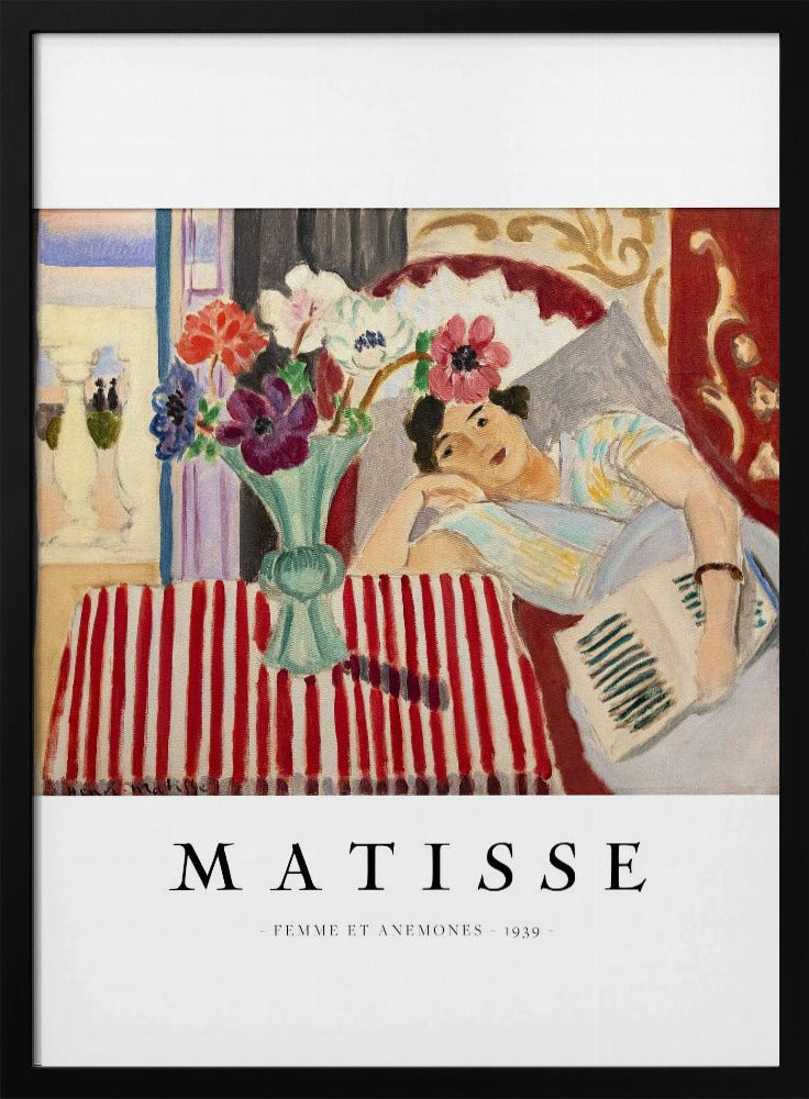 A poster featuring Henri Matisse's 1939 painting, 'Femme et Anemones'. The artwork depicts a woman in a colorful top reclining on a couch, holding a book. Beside her, on a red and white striped tablecloth, sits a vase filled with vibrant anemone flowers. The poster has a black frame and white matting, with 'MATISSE' printed below the image. Artwork