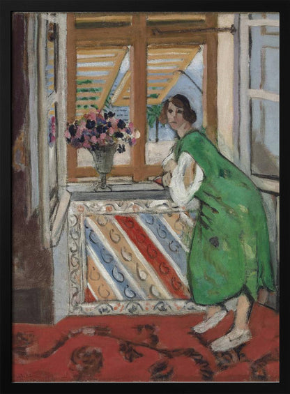 A painting by Henri Matisse depicting a woman in a loose green dress leaning on a windowsill and looking towards the viewer. Outside the open window with tan shutters, a sunny scene with a palm tree is visible. A vase of flowers sits on the sill above a colorful striped panel, and a red patterned rug covers the floor. Print
