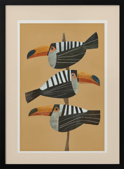 A framed graphic illustration of three stylized toucans perched one above the other on a thin vertical branch. The birds, facing left, have black bodies with bold white vertical stripes, and large, vibrant orange beaks. The background is a solid mustard yellow. Decor
