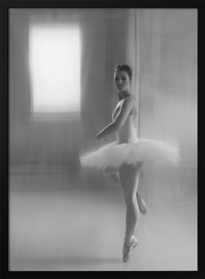 A black and white artistic photograph of a ballerina in a white leotard and tutu, mid-pose on pointe. The image has a motion blur effect, creating a dreamy and ethereal atmosphere as she glances back at the camera. Decor