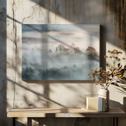 An atmospheric landscape photograph of a forest shrouded in thick, rolling fog, with the bare branches of treetops emerging from the mist, creating a serene and mysterious scene, presented in a silver frame. Wall Art