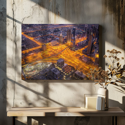 A stunning aerial view of a futuristic city at night, with brilliantly lit highways forming intricate patterns of golden light amidst towering skyscrapers, enclosed in a silver frame. Poster