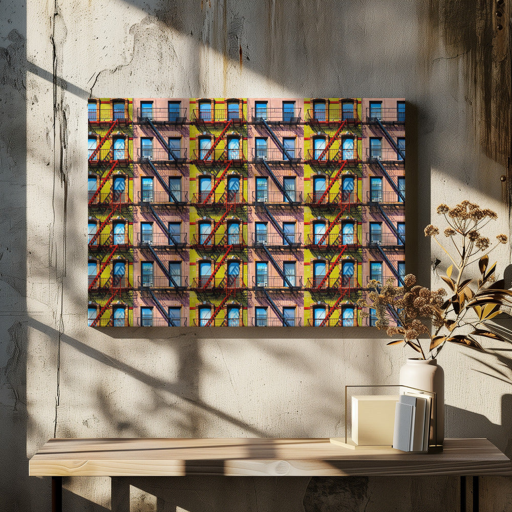 A pop-art style repeating pattern of a colorful apartment building facade featuring pink and yellow walls, windows reflecting a blue sky, and a network of black and red fire escapes, enclosed in a silver frame. Artwork
