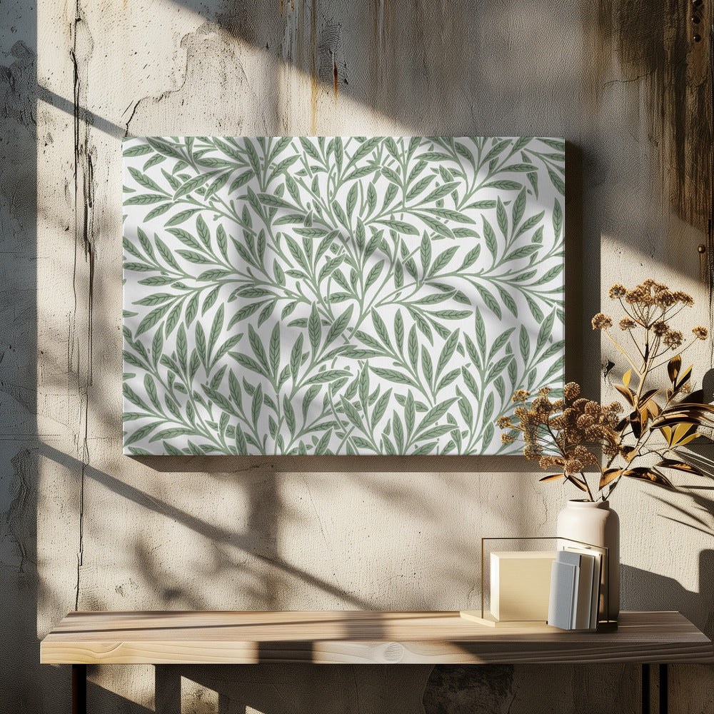 A framed art print with a repeating pattern of sage green leaves and branches on a white background. The style is elegant and inspired by nature, and the print is housed in a simple silver frame. Poster