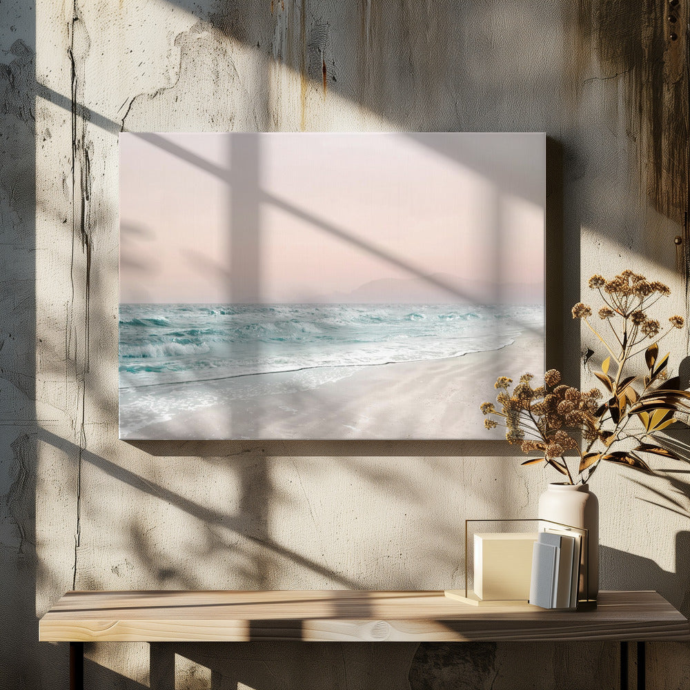 A serene coastal scene with gentle turquoise waves washing onto a sandy beach. The sky is a soft, hazy pink, and faint outlines of mountains are visible in the distant background. The artwork is presented in a silver frame. Print