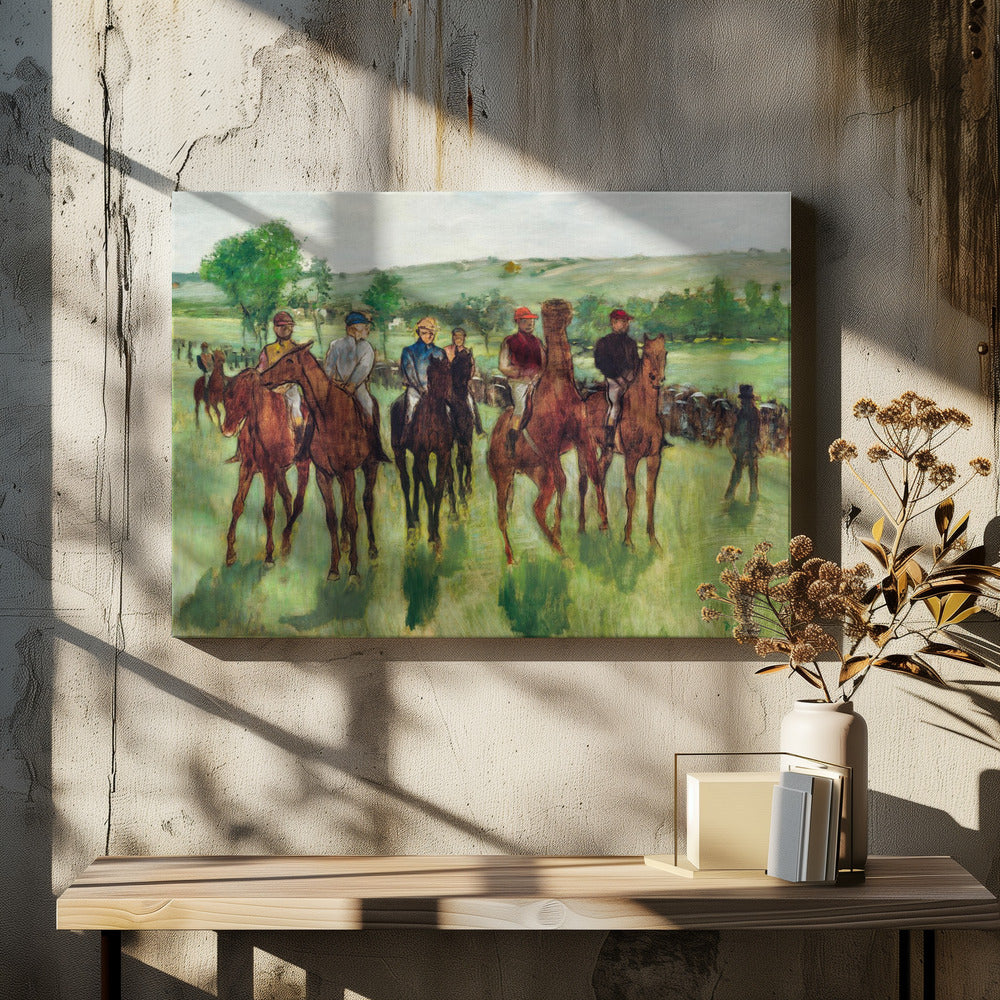 An impressionist painting by Edgar Degas titled 'The False Start', depicting a group of jockeys on their racehorses in a verdant field. The riders are dressed in colorful caps and silks, waiting against a backdrop of rolling green hills and a pale sky. The artwork is displayed in a modern silver frame. Artwork