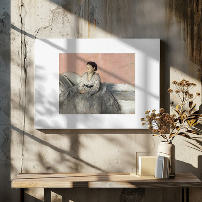 A framed impressionist painting of a woman with dark hair sitting on a bed against a dusty rose background. She wears a white, dotted blouse and a voluminous gray skirt, looking thoughtfully to her left. The painting is set in a silver frame with a white mat. Poster