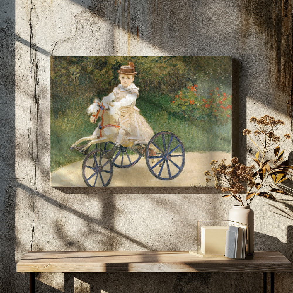 An Impressionist painting by Claude Monet depicting his son, Jean, riding a toy horse tricycle. The young boy wears a brown hat and a light-colored outfit, sitting on a white hobby horse with large blue wheels, set against a lush green garden background. Decor
