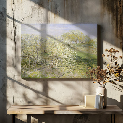 An impressionist painting of an orchard in full bloom, with white and yellow blossoms covering the trees. The orchard is set on a rolling green hillside under a pale, hazy sky, with soft shadows cast on the grass. The artwork is presented in a silver frame. Wall Art