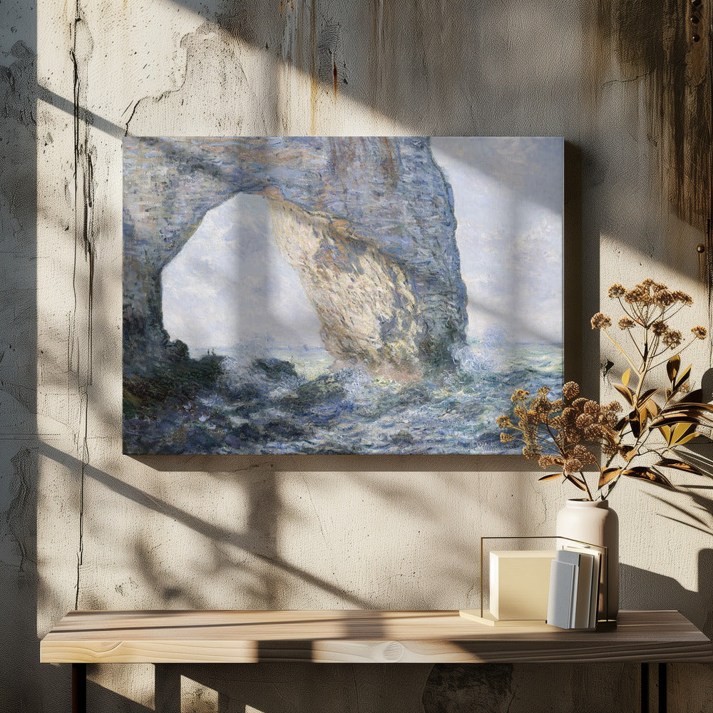 An impressionist painting by Claude Monet of the Manneporte rock arch at Étretat, France. Sunlight illuminates the massive stone arch as turbulent blue and white waves crash against the rocky shoreline below. The artwork is displayed in a silver frame. Decor