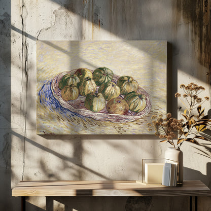 A post-impressionist still life painting by Vincent van Gogh showing a woven basket full of green and yellow apples. The background is a textured pale yellow, and the artist's signature is visible in the bottom left. The artwork is presented in a silver frame. Poster