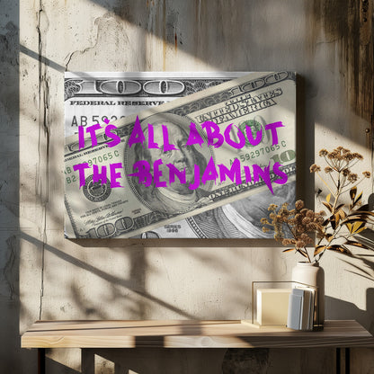 A pop art piece featuring a close-up of a one-hundred-dollar bill. The phrase 'IT'S ALL ABOUT THE BENJAMINS' is written across the image in a messy, graffiti-style font in a vibrant magenta color. The artwork is set within a silver frame. Wall Art