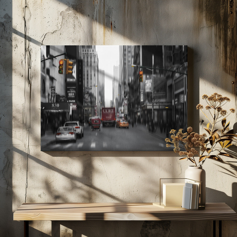 A framed, stylized photograph of a busy New York City street, presented mostly in black and white with a motion blur effect. Pops of color highlight red vehicles and yellow traffic lights, drawing focus down the urban canyon lined with skyscrapers and Broadway signs. Decor