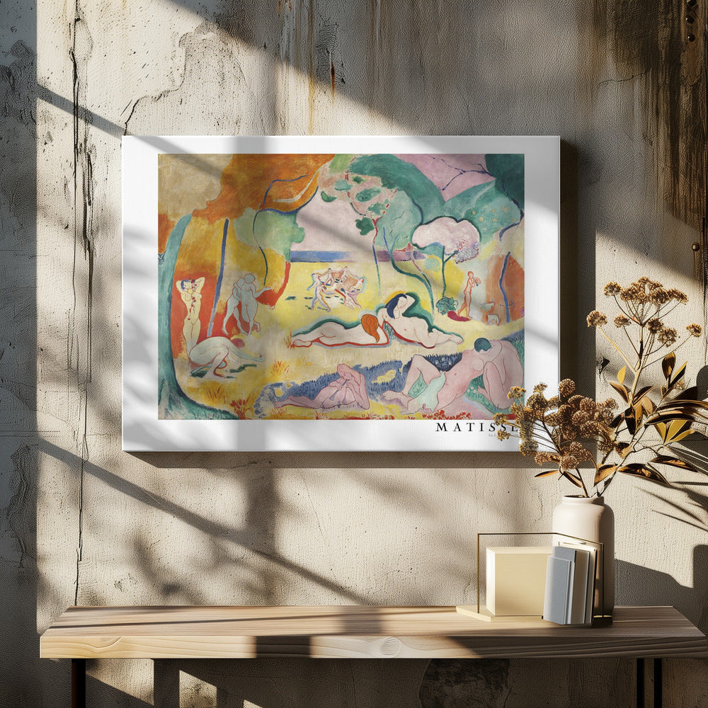 A framed art print of Henri Matisse's famous Fauvist painting, 'Le Bonheur de Vivre' (The Joy of Life). The colorful, idyllic landscape is filled with nude figures lounging, dancing, and playing music under vibrant yellow, orange, and green trees against a pink sky. Wall Art