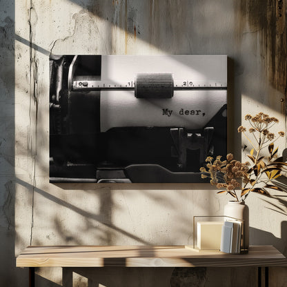 A close-up, black and white photograph of a vintage typewriter. A sheet of white paper is loaded, and the words 'My dear,' have just been typed, creating a sense of nostalgia and romance. The image is enclosed in a silver frame. Wall Art