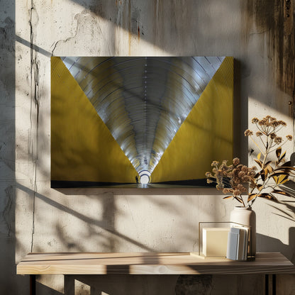 A symmetrical, perspective view down a modern, circular tunnel. The lower walls are bright yellow, creating two diagonal lines that converge towards a bright, white light at the far end. The arched ceiling is made of reflective silver metal panels, and a small silhouette stands near the exit. Artwork