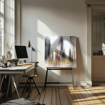 An artistic photograph of New York City's Flatiron Building in a light wood frame. The image has a strong vertical motion blur effect, creating streaks of yellow from taxi cabs and gray from the surrounding architecture, capturing the bustling energy of the city. Poster