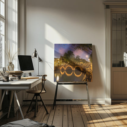 An idyllic nightscape view of Keizersgracht canal in Amsterdam, featuring illuminated buildings reflecting on the water under a dark sky. Wall Art