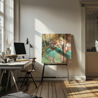 An impressionist painting of four ballet dancers in green tutus backstage. The dancers are adjusting their costumes and hair against a warm, painterly background of yellow, orange, and brown tones. The artwork is displayed in a light wood frame. Wall Art