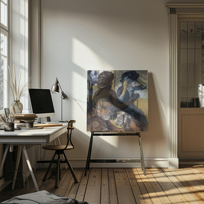 A framed impressionist painting by Edgar Degas, 'The Millinery Shop', depicting two women. One woman, seen from the back, wears a brown coat and hat, while the other tries on a dark blue hat, adjusting it with her gloved hands. Colorful hats are displayed in the foreground. Print