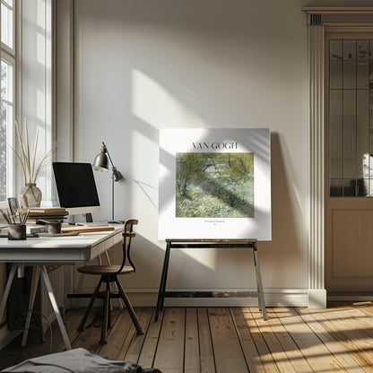 A framed art print of Vincent van Gogh's painting 'River Bank in Springtime'. The impressionist artwork depicts a lush green riverside scene with white flowers and a distant bridge, framed in light wood with a white mat. Wall Art