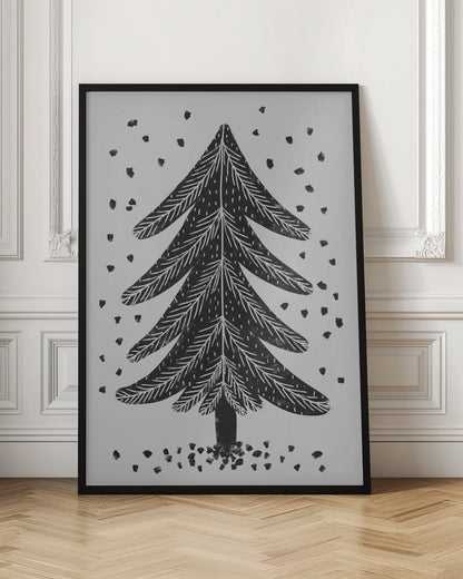 A black and white block print illustration of a stylized Christmas tree against a light gray background. Black specks representing falling snow surround the tree. The artwork has a rustic, folk art feel and is presented in a black frame. Print