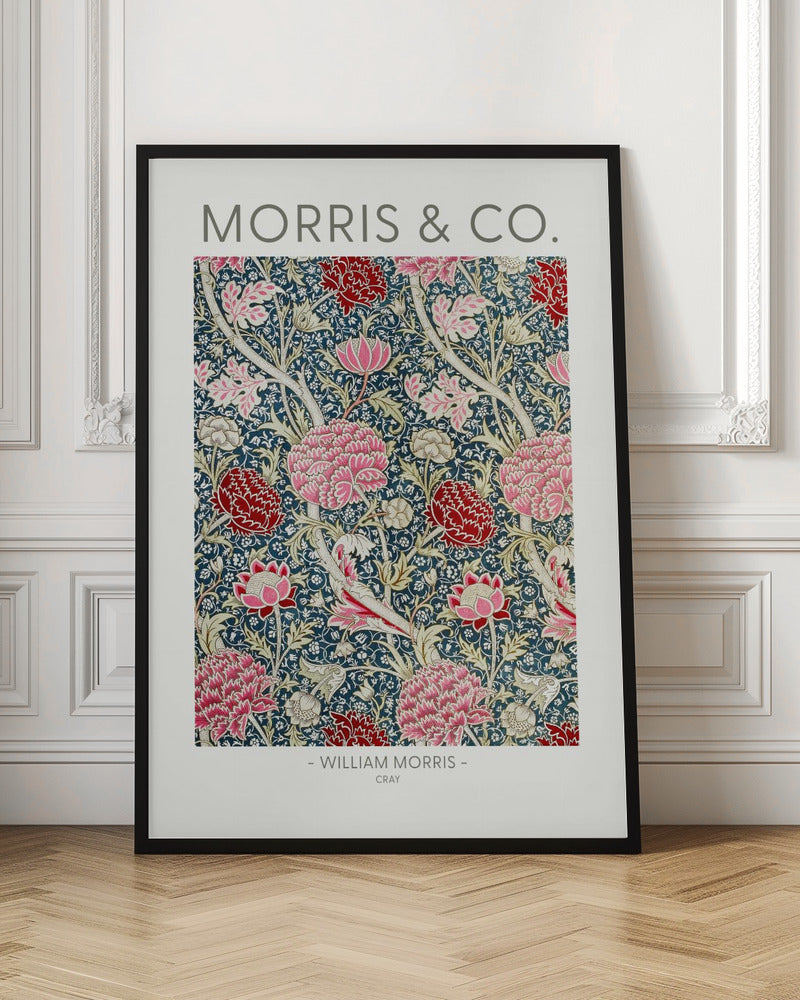 A framed art print of William Morris's 'Cray' pattern, featuring a dense floral design with large pink and red stylized flowers and foliage on a dark navy blue background. The text 'MORRIS & CO.' is above the pattern, and '- WILLIAM MORRIS - CRAY' is below. Artwork