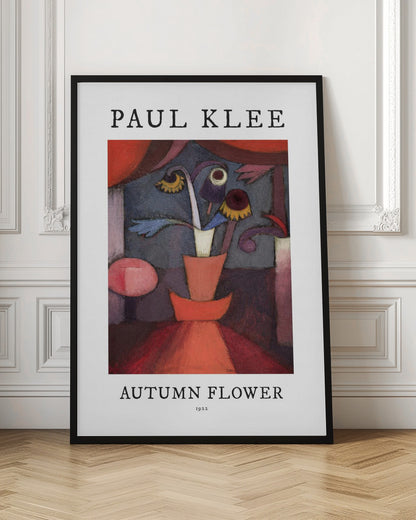 A poster of Paul Klee's 1922 painting 'Autumn Flower'. The abstract artwork features a stylized vase with surreal flowers in shades of red, orange, blue, and purple. The poster has a white border with 'PAUL KLEE' at the top and 'AUTUMN FLOWER 1922' at the bottom, all within a thin black frame. Poster
