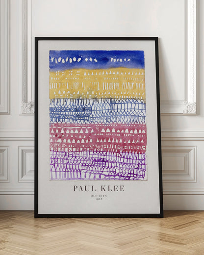 A framed art print of Paul Klee's 1928 watercolor painting 'Old City.' The abstract piece features horizontal bands of color, from top to bottom: a dark blue sky, a yellow section with building-like patterns, and layers of intricate lattice-like designs in blue, magenta, and purple. Artwork