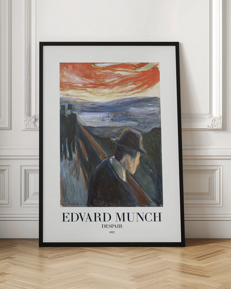 A framed art print of Edvard Munch's 1892 painting, 'Despair'. The expressionist artwork depicts a man in a dark coat and hat leaning over a bridge railing in profile, with a fiery red and orange sunset in the background. Below the image, text reads 'EDVARD MUNCH DESPAIR 1892'. Print