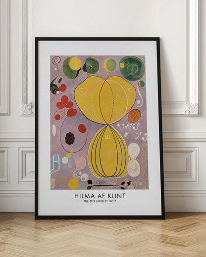 A framed art print of Hilma af Klint's abstract painting, 'The Ten Largest, No. 7.' The artwork features two large central yellow organic shapes on a lavender background, surrounded by smaller colorful forms including red clovers, green circles, and delicate spirals. Print