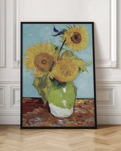 A framed reproduction of Vincent van Gogh's famous 'Sunflowers' painting, featuring three large yellow sunflowers in a green vase against a light blue background, painted in his iconic post-impressionist style with thick brushstrokes. Wall Art