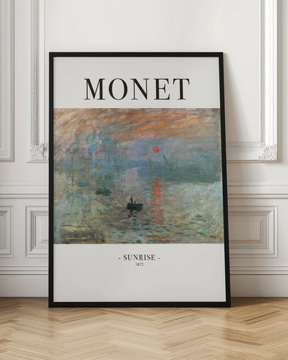A framed art poster of Claude Monet's famous painting, 'Impression, Sunrise'. The top of the poster reads 'MONET' and the bottom reads '- SUNRISE - 1872'. The impressionist painting shows a hazy sunrise over a harbor, with a bright orange sun reflecting on the blue-grey water and small boats silhouetted in the foreground. Poster