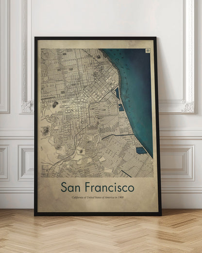 A framed vintage map of San Francisco from 1900. The map is detailed on aged, beige paper, with the bay depicted in a deep teal blue. Below the map, text reads 'San Francisco' and 'California of United States of America in 1900'. Artwork
