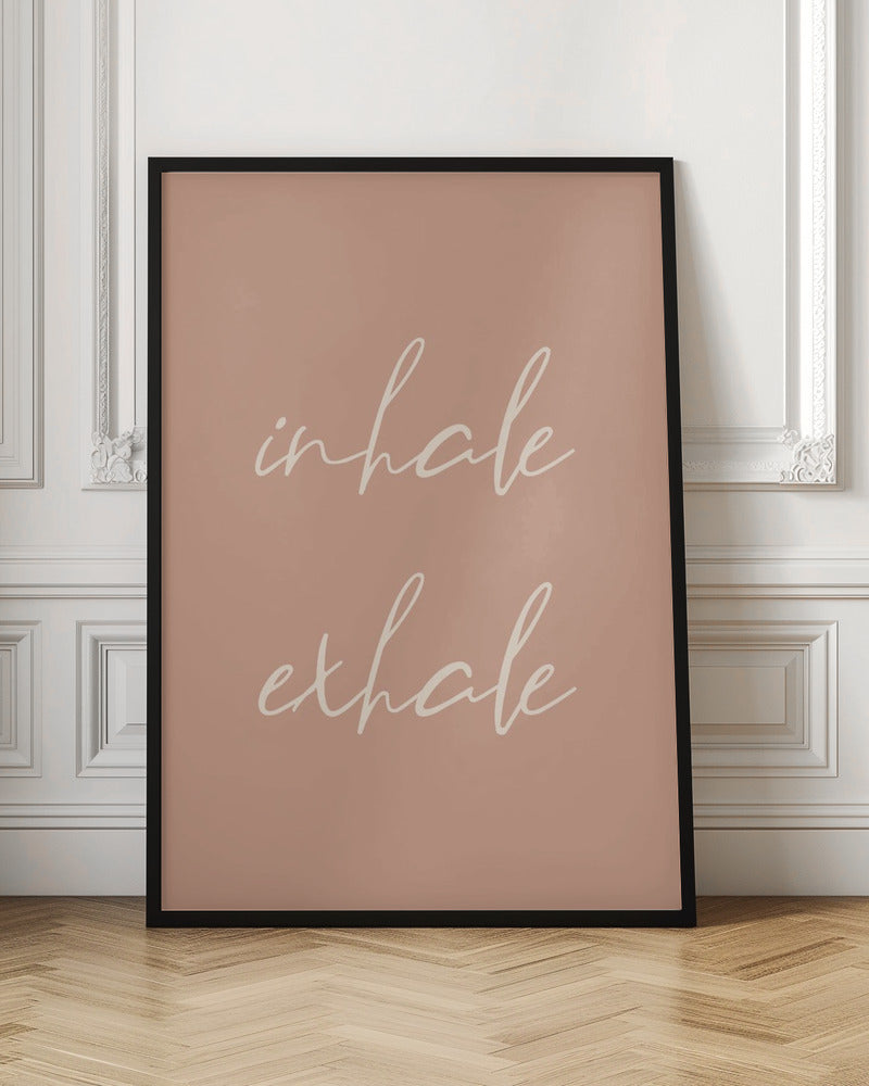 A minimalist framed poster featuring the words 'inhale' and 'exhale' in a flowing white script font, stacked vertically against a solid dusty pink background. Poster