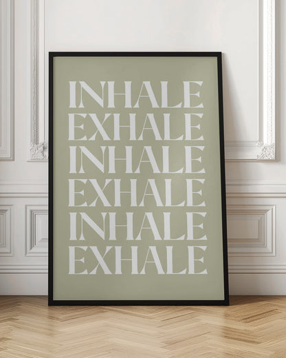 A minimalist art print featuring the words 'INHALE' and 'EXHALE' repeated in a vertical column. The text is in a bold, white serif font against a calming sage green background, all enclosed in a simple black frame. Print