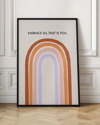 A framed art print with an inspirational quote. On a cream background, the black text reads 'EMBRACE ALL THAT IS YOU.' Below the text is a large, stylized U-shaped rainbow with thick, painted bands of terracotta, orange, pink, and lavender. Print