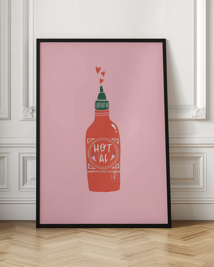 A graphic illustration of a red hot sauce bottle with a green cap on a pink background. The label on the bottle humorously reads 'HOT AF'. Three small red hearts float up from the nozzle, all enclosed within a thin black frame. Wall Art