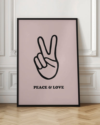 A minimalist art print with a light pink background featuring a bold black outline of a hand making a peace sign. Below the hand, the words 'PEACE & LOVE' are printed in a black serif font. The print is enclosed in a simple black frame. Print