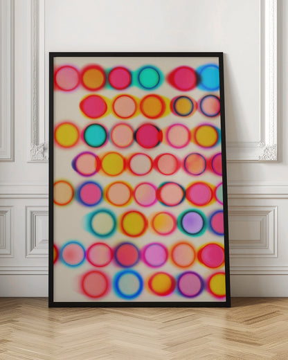 An abstract artwork in a black frame featuring rows of colorful, blurry circles on a cream background. The circles, in shades of pink, yellow, blue, and orange, have a soft-focus, glowing effect and overlap, creating a vibrant, energetic pattern with a slight 3D appearance. Poster