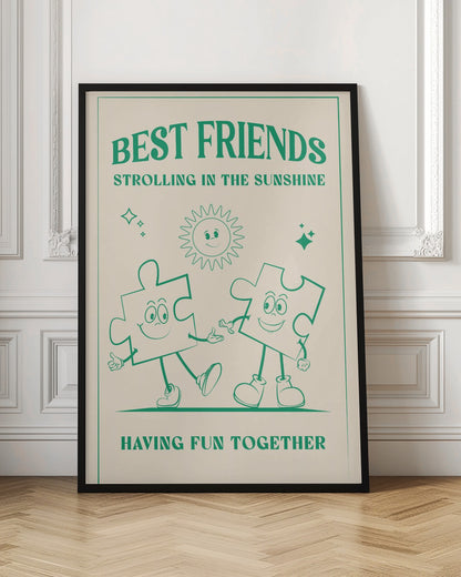 A vintage-style poster with a cream background and green artwork. At the top, it reads 'BEST FRIENDS' and 'STROLLING IN THE SUNSHINE'. The central image shows two smiling cartoon puzzle pieces with arms and legs, walking hand-in-hand under a cheerful cartoon sun. At the bottom, the text says 'HAVING FUN TOGETHER'. The artwork is enclosed in a green border and presented in a black frame. Artwork