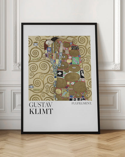 A framed poster of Gustav Klimt's painting 'Fulfillment'. It features a stylized man and woman embracing, wrapped in ornate, mosaic-like robes against a background of golden swirls. Below the image is the text 'GUSTAV KLIMT' and 'FULFILLMENT.'. Wall Art