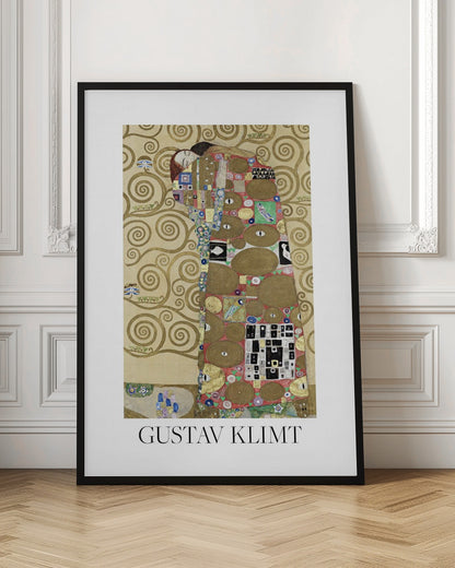 A framed art print of Gustav Klimt's painting 'Fulfillment,' featuring a stylized couple embracing. They are enveloped in ornate, patterned robes with geometric and circular motifs, set against a golden background with swirling patterns. The artist's name, 'GUSTAV KLIMT,' is printed below the image. Wall Art