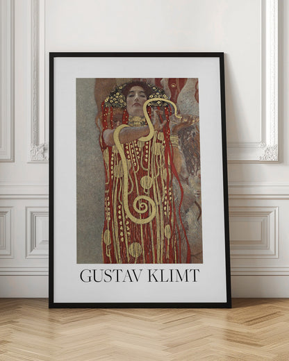 A poster of Gustav Klimt's 'Hygieia', featuring a woman with an elaborate headdress and a red and gold patterned robe. A large golden snake is wrapped around her arm as she holds up a bowl. The poster has a white border with 'GUSTAV KLIMT' written at the bottom and is displayed in a black frame. Wall Art