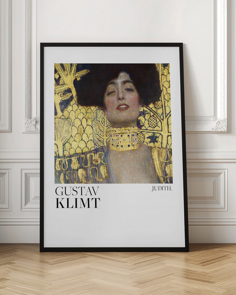 A framed art print of Gustav Klimt's painting 'Judith I'. The artwork features a portrait of a woman with dark hair and a gold choker against a lavish gold-leaf background. The artist's name and the title 'JUDITH.' are printed below the image on a white border. Print