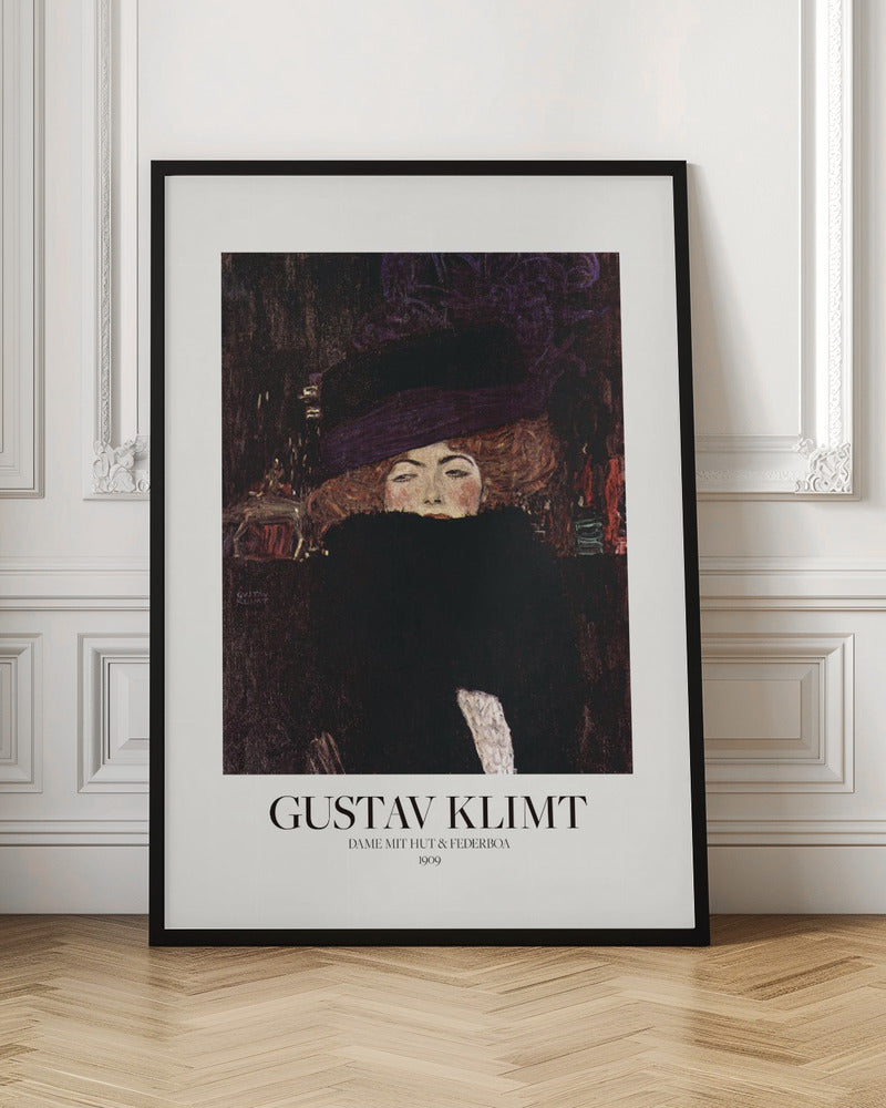 A framed art print of Gustav Klimt's 1909 painting, 'Lady with Hat and Feather Boa'. It features a portrait of a woman with auburn hair, a large purple hat, and a black feather boa obscuring her mouth, set against a dark, textured background. Poster
