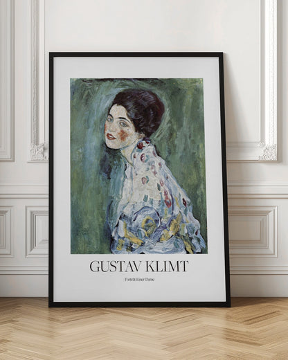 A framed art print poster of Gustav Klimt's "Portrait of a Lady". The painting depicts a woman with dark, upswept hair and blue eyes against a textured green background. The poster includes the text "GUSTAV KLIMT" and "Porträt Einer Dame" below the artwork. Wall Art