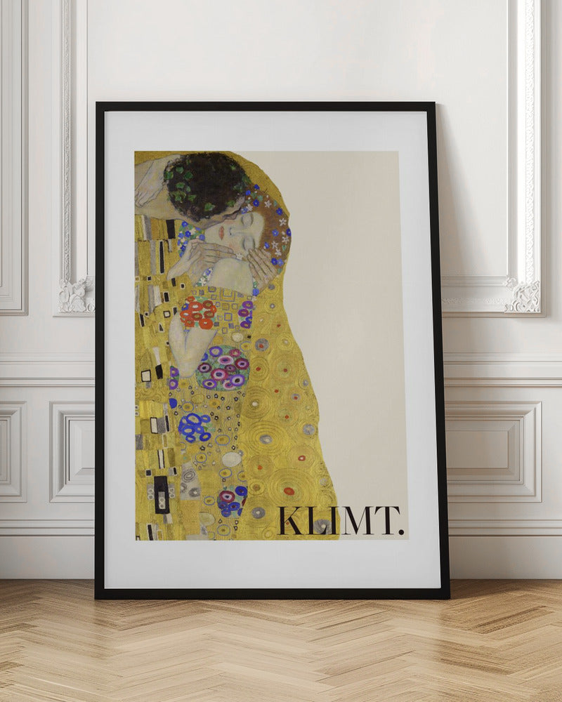 A framed art print of Gustav Klimt's 'The Kiss'. A couple embraces in ornate golden robes against a shimmering gold background. The poster includes the artist's name 'KLIMT.' in the lower right. Decor