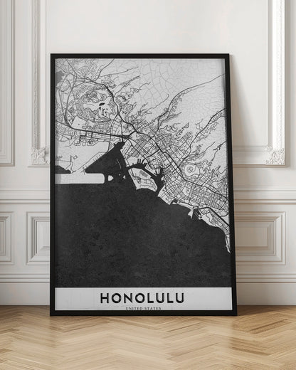 A framed, minimalist black and white map of Honolulu, Hawaii. The city's streets and coastline are rendered in black lines on a white background, while the ocean is a solid, textured black. The word 'HONOLULU' is printed in black sans-serif font at the bottom. Artwork
